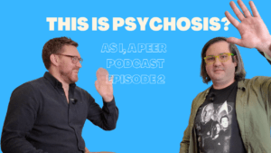 Two men smiling and waving on a blue background with the text “This Is Psychosis?” promoting a peer support podcast episode about lived experience and mental health.