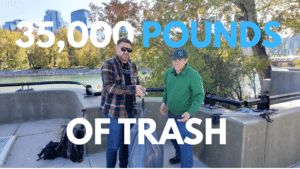 Jeff Turner and a guest weighing a large trash bag outdoors along the Bow River in Calgary, with the city skyline in the background.